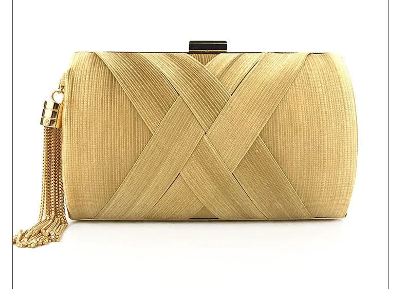 Gold clutch bag with woven design and tassel on a white background