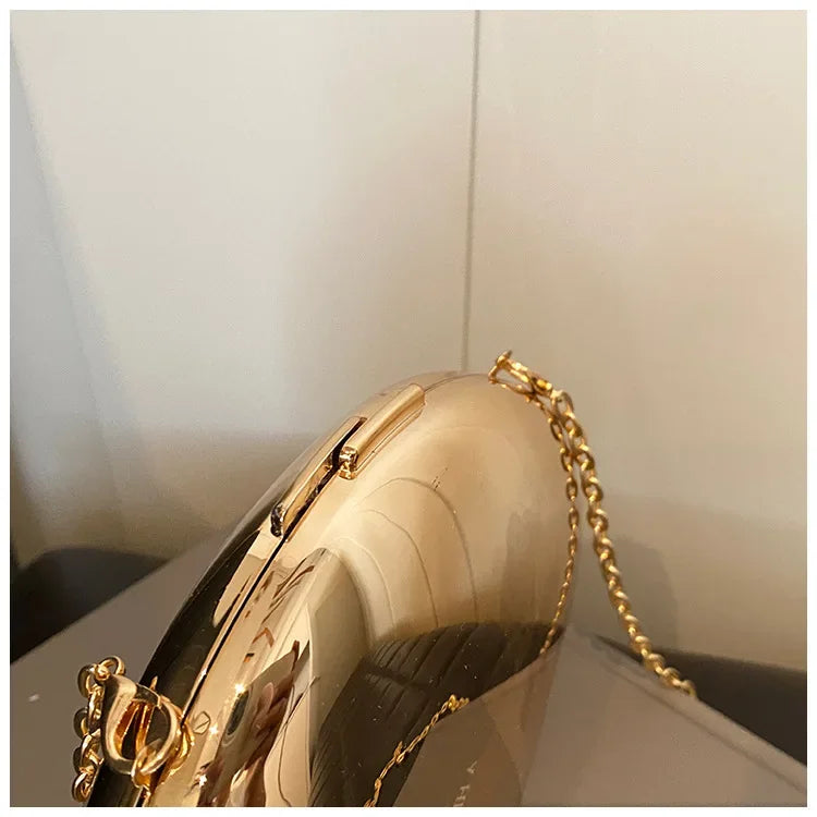 Elegant Acrylic Shell Shape Clutch Bag with a shiny gold finish and a stylish chain strap