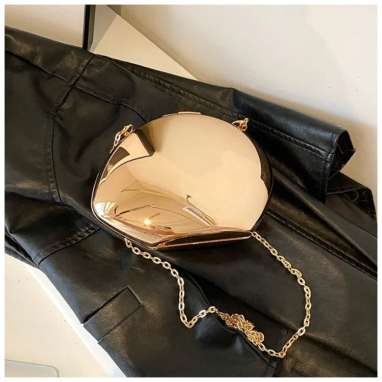 Gold Acrylic Shell Shape Clutch Bag with Chain Strap on Black Leather Background