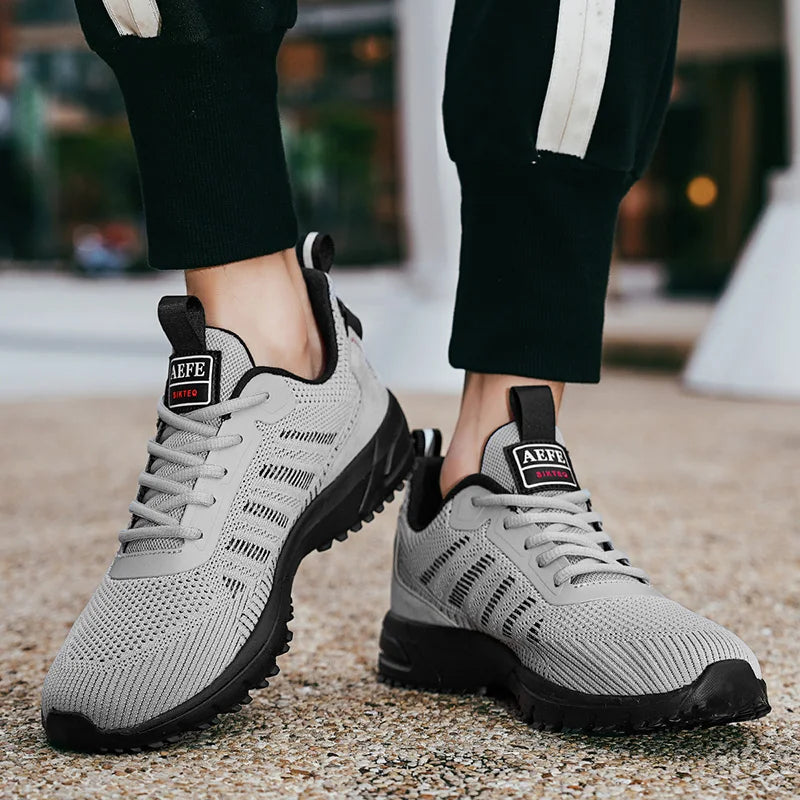 VaultHaus lightweight athletic sneakers for men in gray with black soles worn outdoors