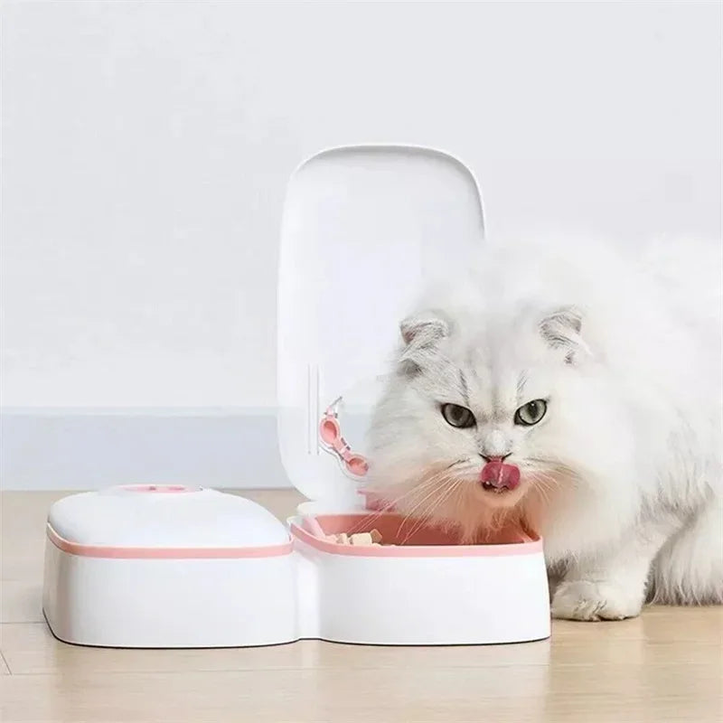 VaultHaus automatic pet food dispenser in white with a cat enjoying its meal