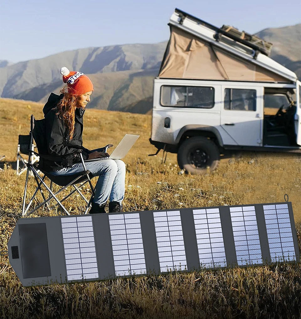 VaultHaus camping portable solar panel charger powering laptop outdoors by camper van