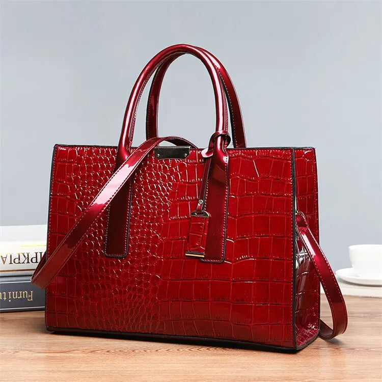 Stylish red crocodile print tote bag with sturdy handles and a modern design