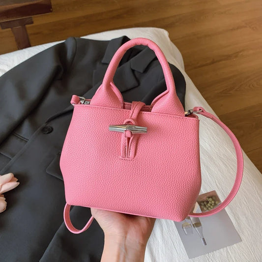VaultHaus designer women's leather shoulder bag in pink with silver clasp and structured handles