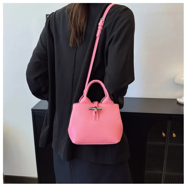VaultHaus designer women's leather shoulder bag in pink worn over the shoulder with adjustable strap