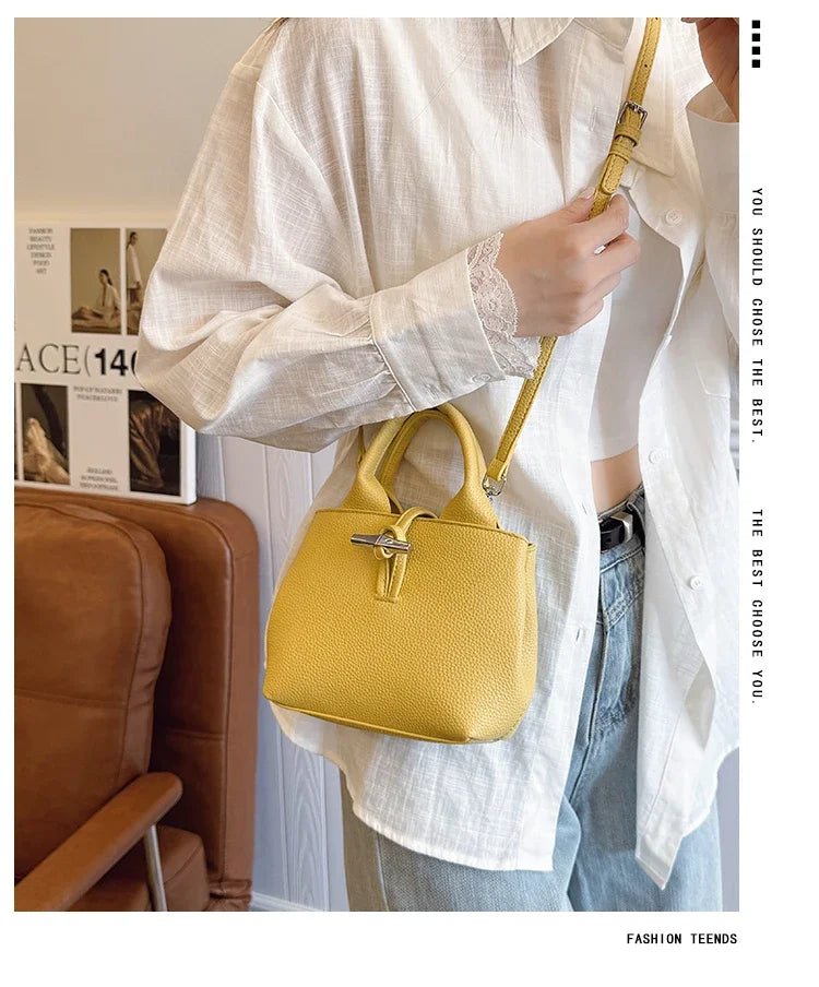 VaultHaus designer women's leather shoulder bag in yellow worn with white blouse and jeans