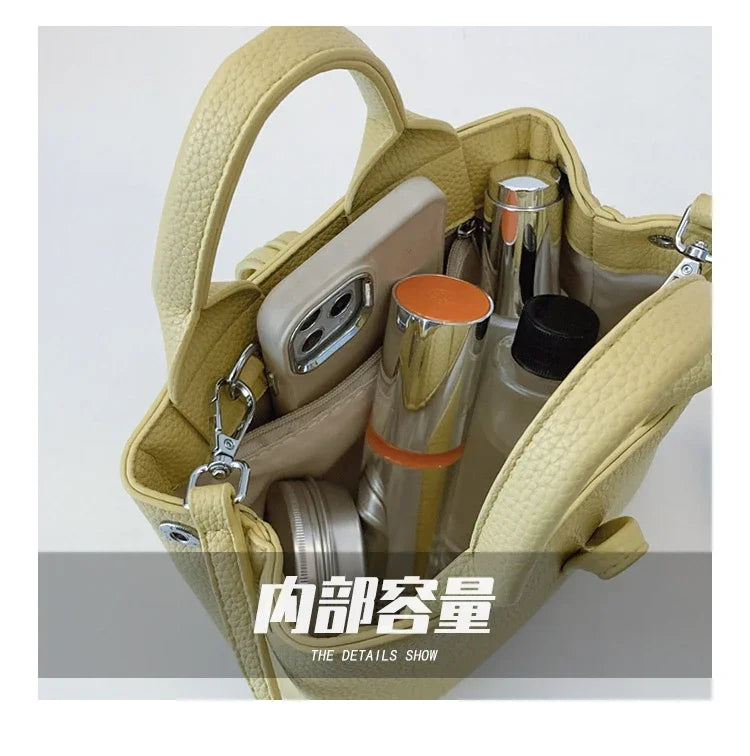 VaultHaus designer women's leather shoulder bag in light yellow showing interior with phone and cosmetics