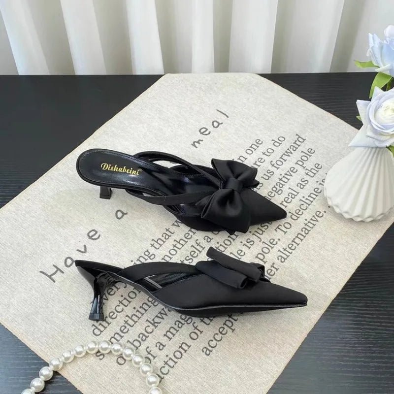 Elegant black slingback heels with bow detailing for stylish looks, perfect to pair with French style pink slippers