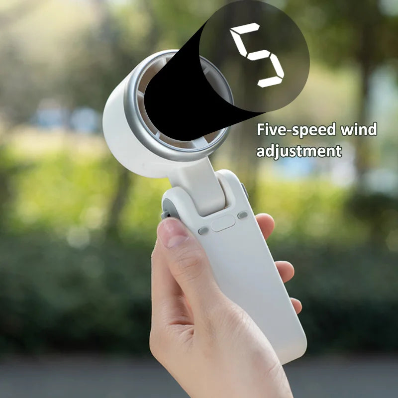 VaultHaus handheld turbo fan with five-speed wind adjustment held outdoors for personal cooling