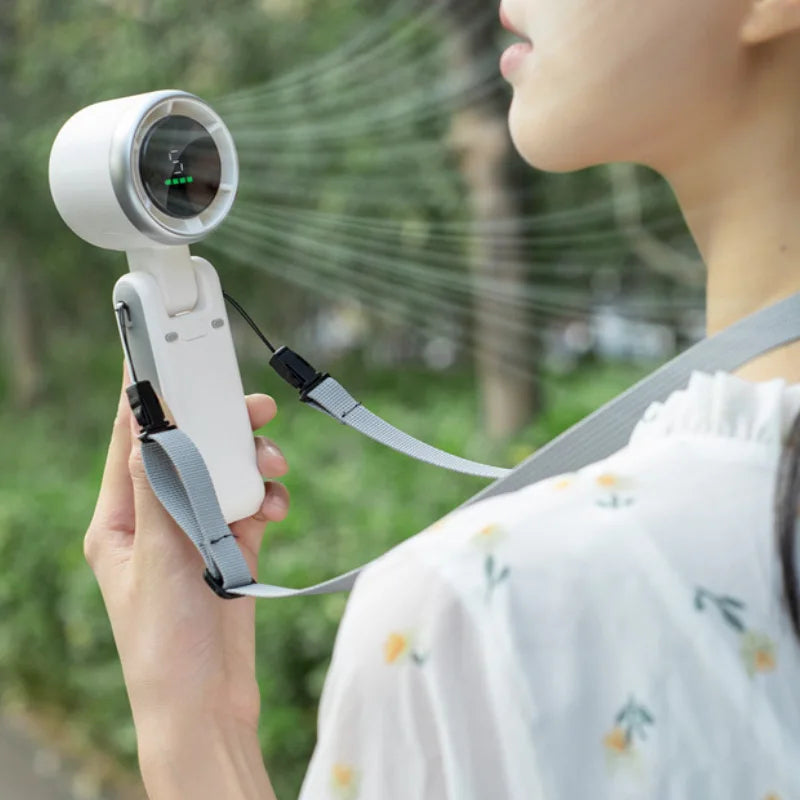 VaultHaus handheld turbo fan blowing air with adjustable strap held by a person outdoors