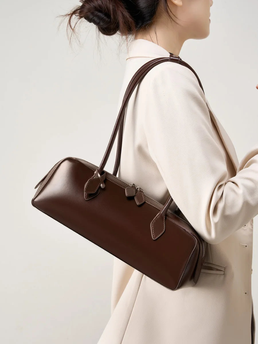 Stylish ladies baguette shoulder bag in brown, featuring elegant straps for a chic look.