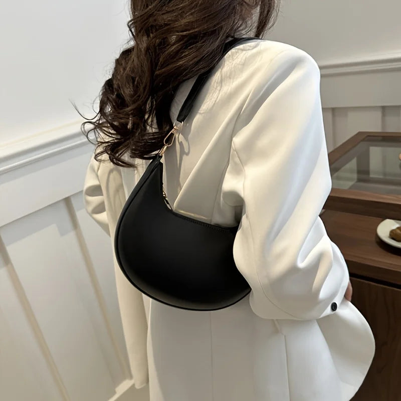 Chic woman carrying a luxury moon-shaped handbag in black, perfect for stylish occasions