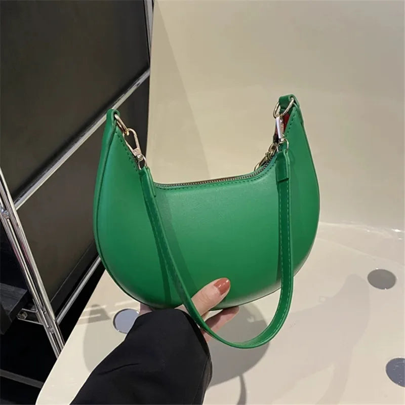 Green luxury moon-shaped handbag with a sleek design, perfect for stylish outings