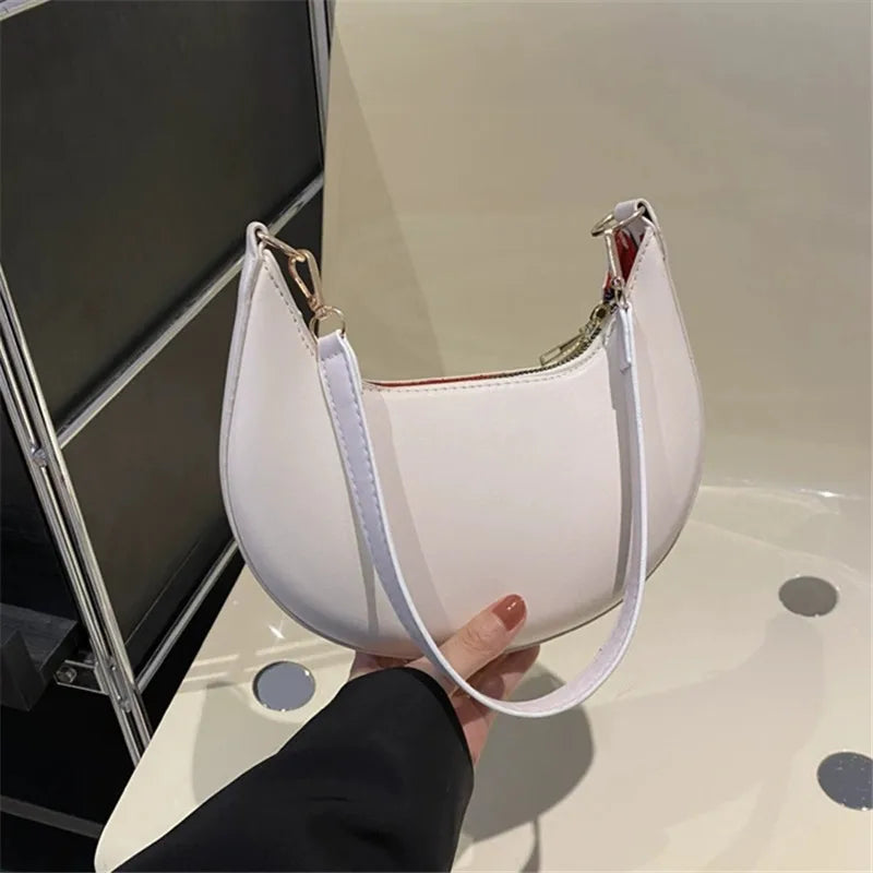 Stylish white luxury moon-shaped handbag with a sleek design and comfortable shoulder strap