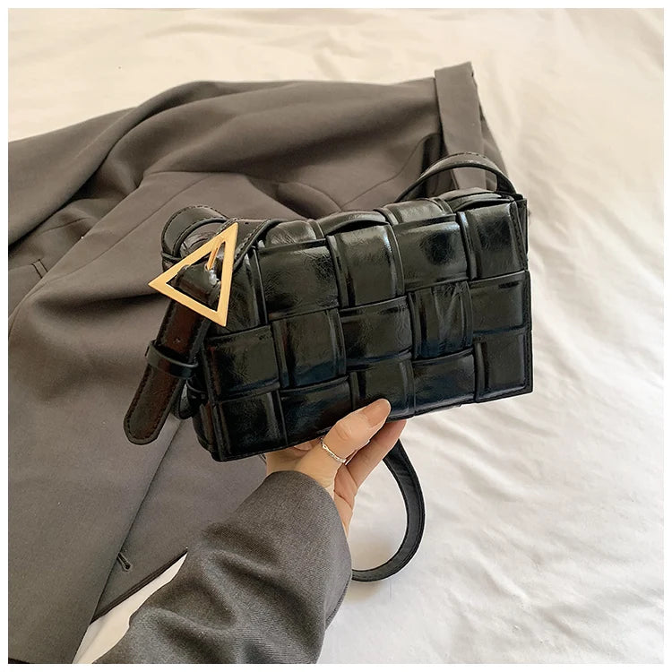 VaultHaus women's designer shoulder bag in black woven leather with gold triangle buckle