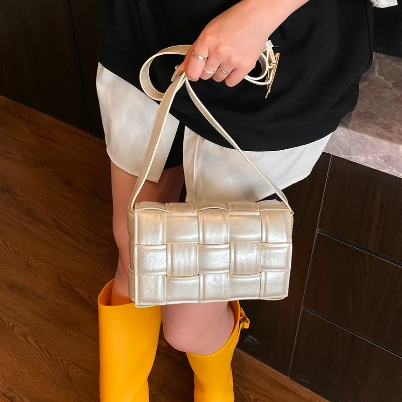 VaultHaus women's designer shoulder bag in pearl white with woven texture held by model wearing yellow boots