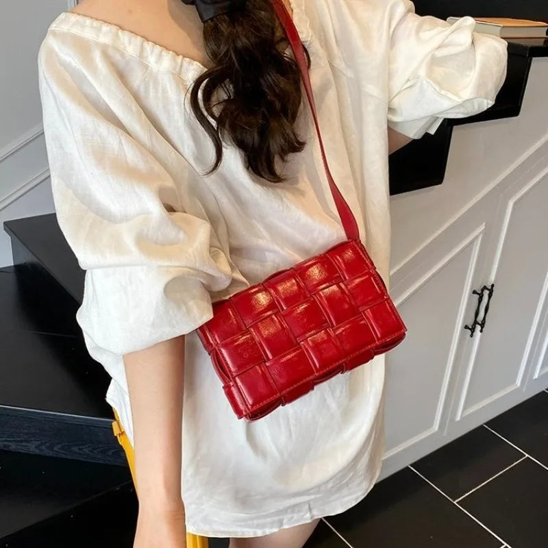 VaultHaus women's designer shoulder bag in red with woven leather pattern worn crossbody