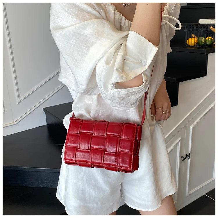 VaultHaus women's designer shoulder bag in red woven leather worn with white outfit