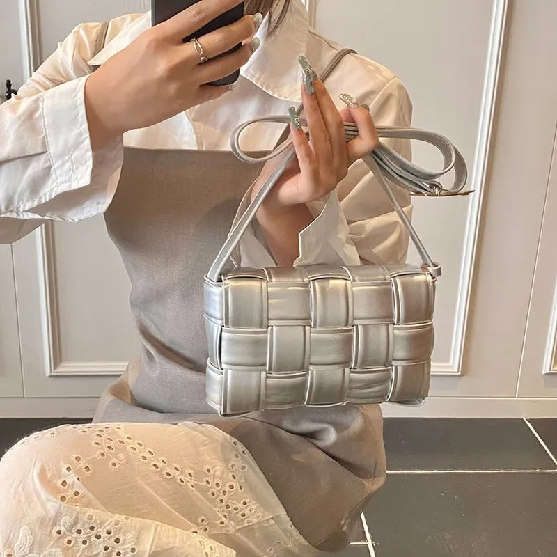 VaultHaus women's designer shoulder bag in silver woven leather held by woman in white blouse
