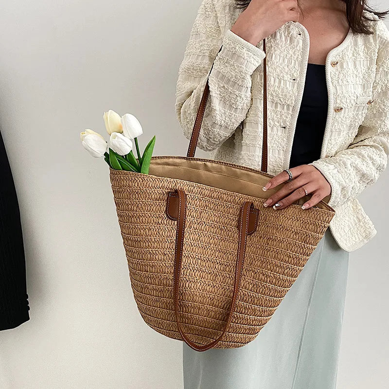 Luxury woven shopper tote in natural color with stylish handles and fresh flowers inside