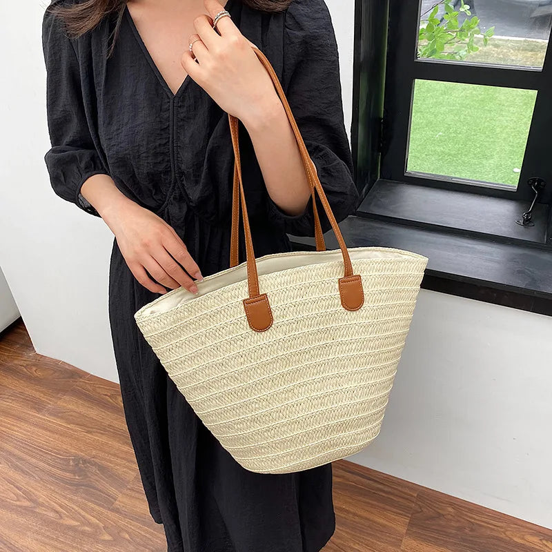 Stylish woman holding a luxury woven shopper tote with leather straps in a bright interior