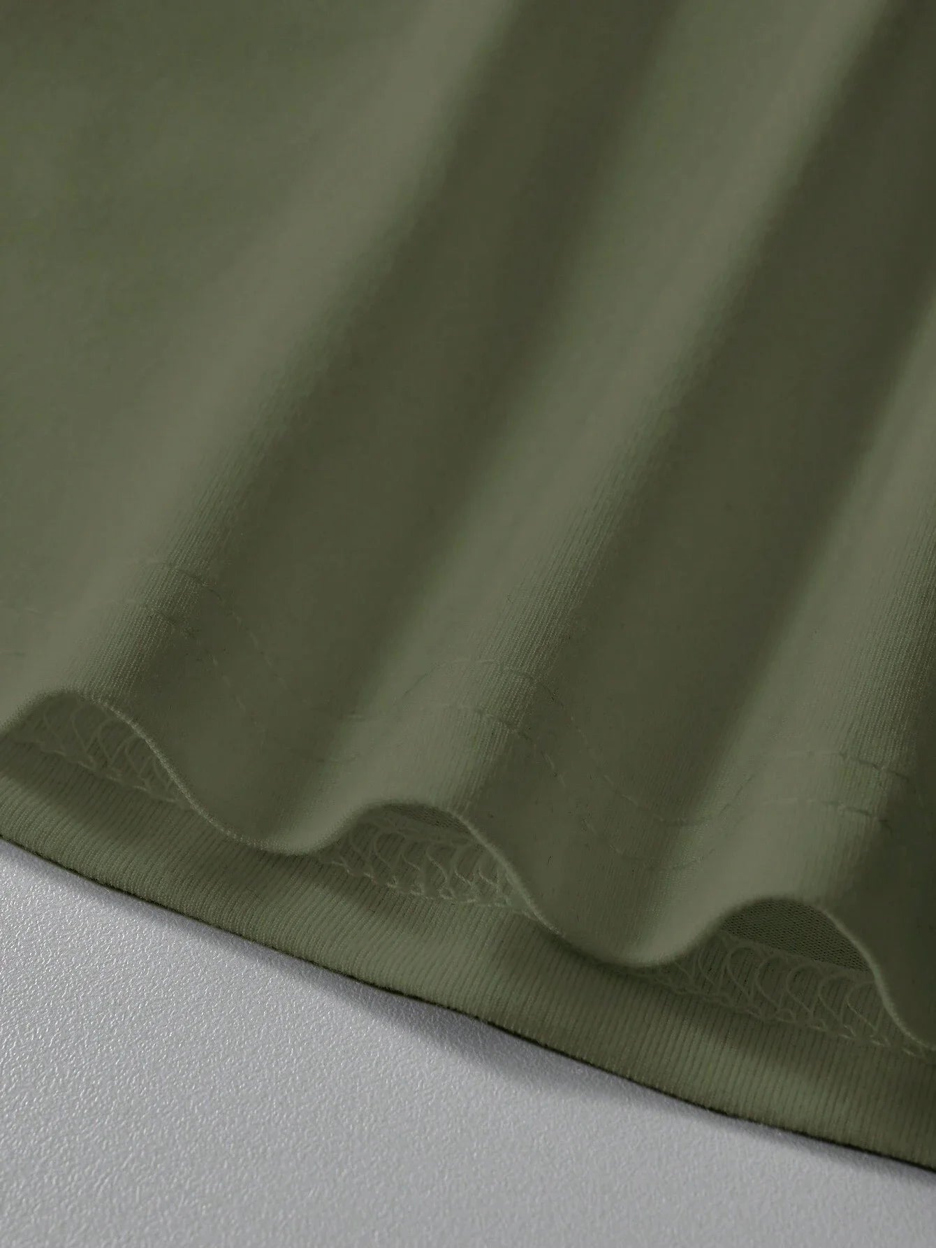 Close-up of men's cotton summer graphic print bear t-shirt in olive green fabric showcasing texture and quality