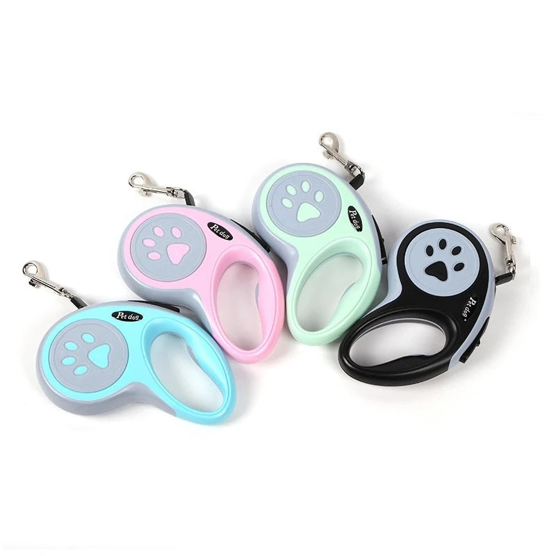Colorful cat and dog retractable leash in pink, blue, and black with paw print designs