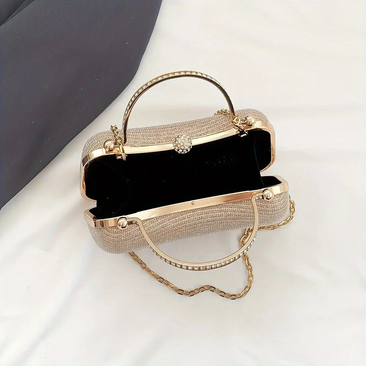 Stylish rhinestone evening bag with a gold frame and chain strap, perfect for formal events