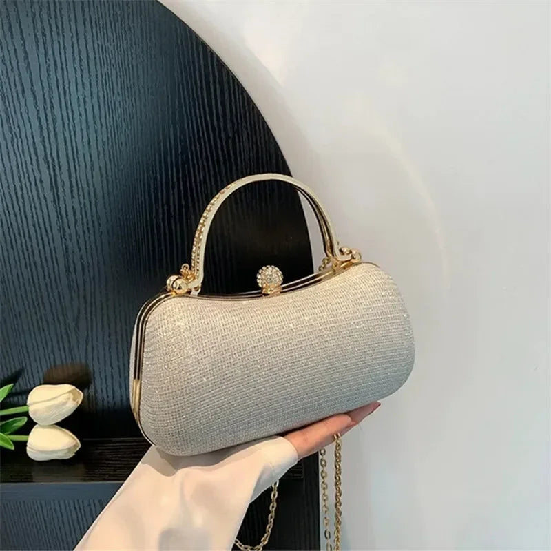 Elegant rhinestone evening bag in silver with a gold clasp and chain strap for formal occasions