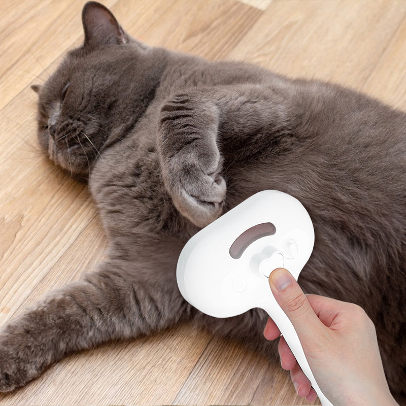 Upgraded Pet Electric Grooming Comb being used to groom a gray cat lying on wooden floor
