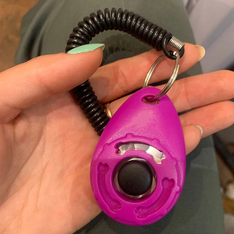 Purple dog training clicker with cord, designed for effective pet obedience training