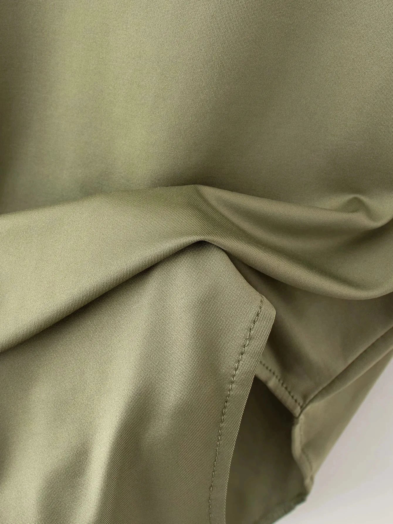 Close-up of soft green fabric showcasing the summer slim bodysuit design by VaultHaus