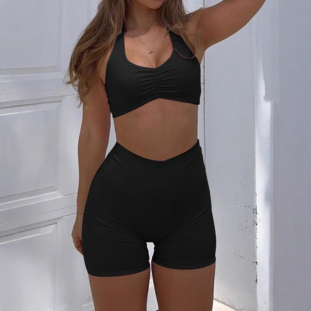 Stylish black women's sportswear set featuring a cropped top and high-waisted shorts