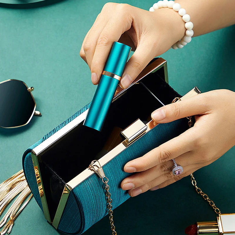 Teal clutch with gold accents held by a hand on a teal background