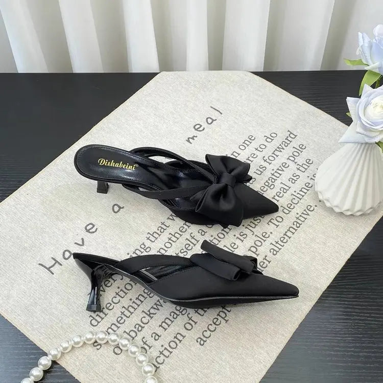 Elegant black slingback heels with bow detail, perfect for pairing with French style pink slippers