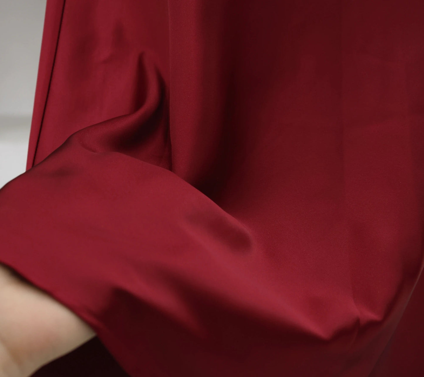 Women's satin elegant midi skirt in rich burgundy color with smooth fabric texture