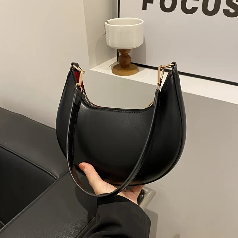 Stylish black luxury moon-shaped handbag with a curved silhouette for elegant looks