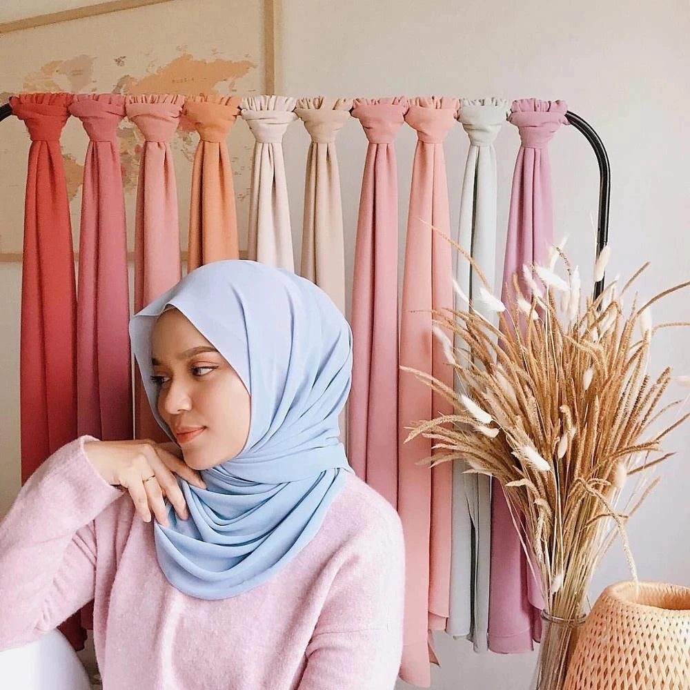 Model wearing a soft blue muslim chiffon hijab scarf with pastel colours in the background