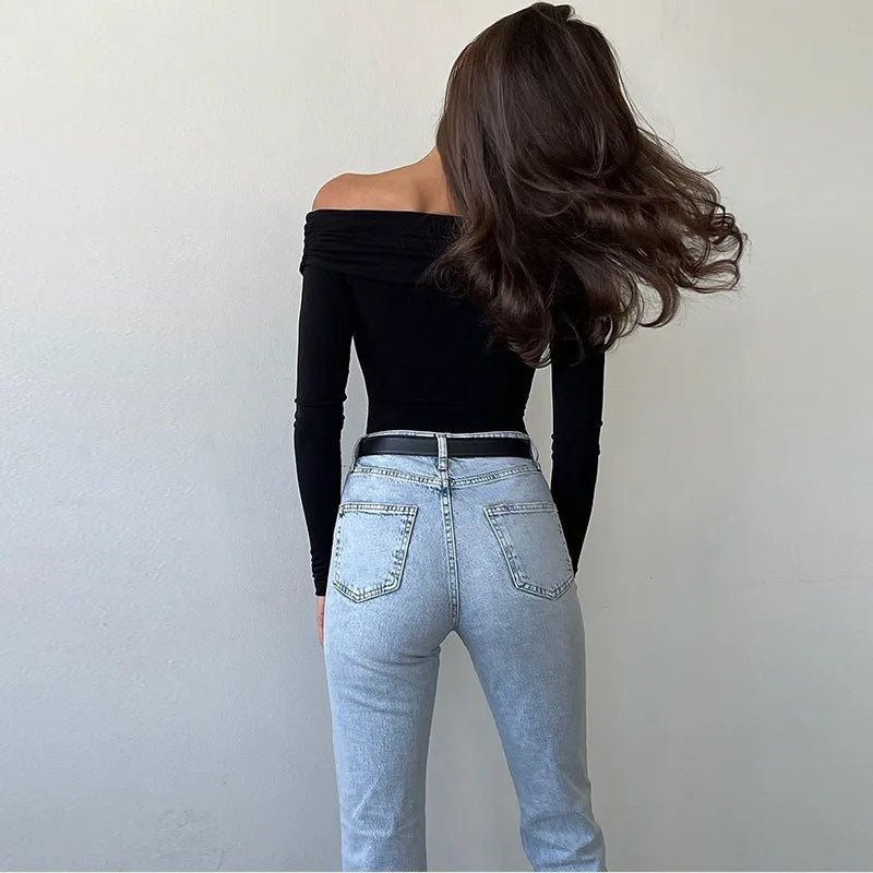 Model showcasing a sexy off shoulder bodysuit paired with stylish high-waisted jeans