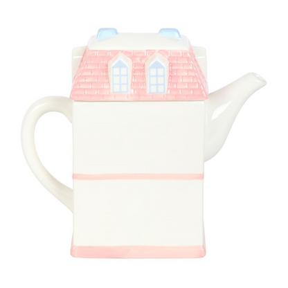 Charming ceramic tea pot shaped like a house with pink roof and decorative windows