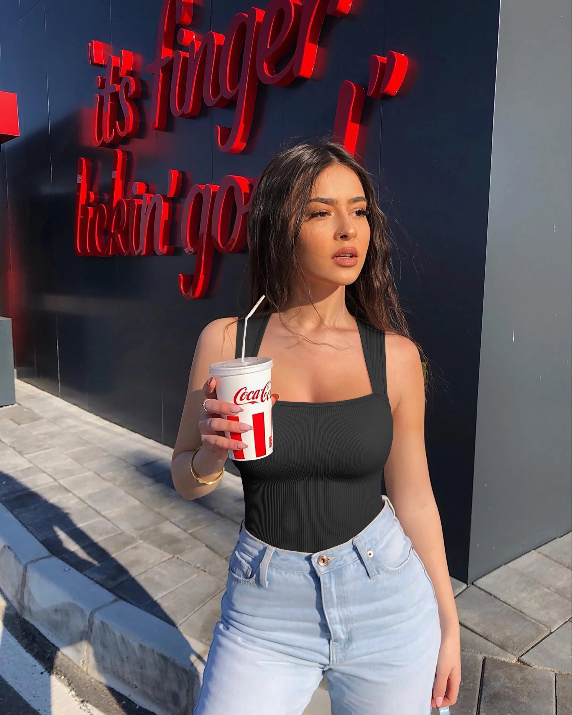 Fashionable black solid color summer bodysuit paired with high-waisted jeans for a trendy look