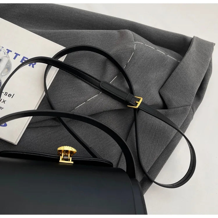 Stylish Women's Classic Versatile Retro Square Bag resting on a gray fabric with decorative stitching