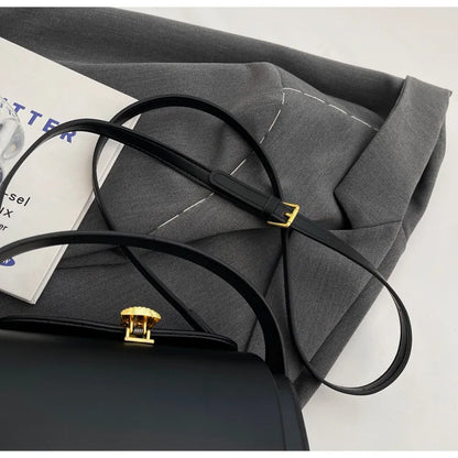 Stylish Women's Classic Versatile Retro Square Bag resting on a gray fabric with decorative stitching