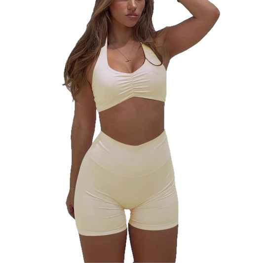 Women in a yellow women's sportswear set featuring a cropped top and high-waisted shorts